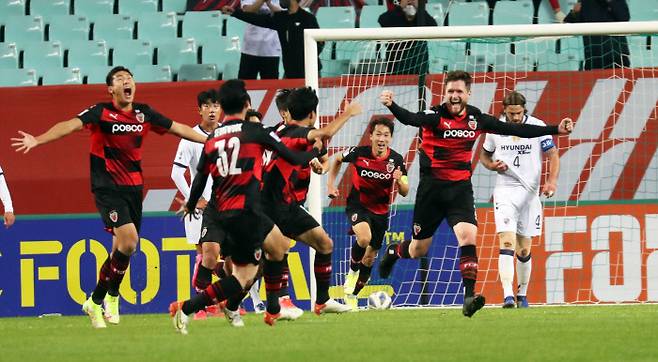 포항 스틸러스의 그랜트(오른쪽)가 20일 전주월드컵경기장에서 열린 울산 현대와 아시아축구연맹 챔피언스리그 준결승전에서 동점골을 넣은 뒤 동료들과 환호하고 있다. 연합뉴스