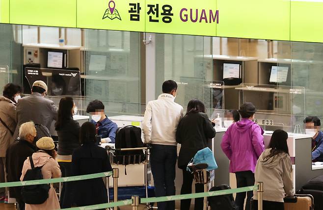 Travelers heading to Guam line up for check-in at Incheon International Airport early Tuesday. (Yonhap)