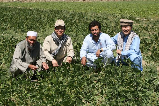 제33회 아산상 사회봉사상 권순영 대표(왼쪽에서 두 번째)가 아프가니스탄 콩 농장에서 현지 농부들과 함께 기념 촬영을 하고 있다.