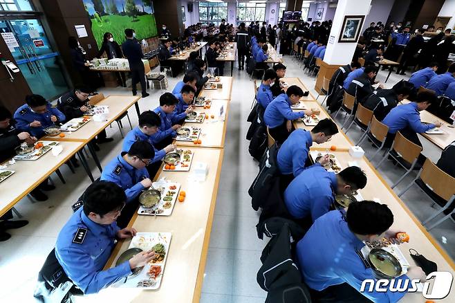 해양경찰청에서 해경 직원들이 신종 코로나바이러스 감염증(코로나19) 예방을 위해 한줄로 앉아 식사를 하고 있다.  (사진은 기사 내용과 무관함) / 뉴스1 © News1