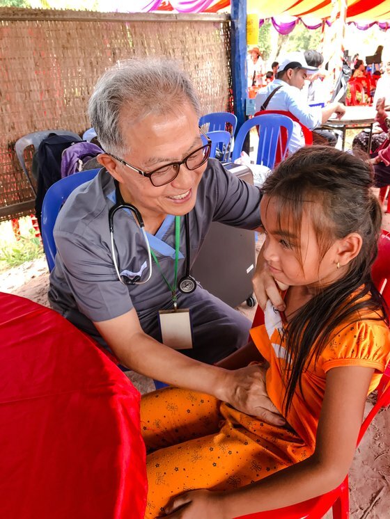제33회 아산상 대상 수상자로 선정된 김우정 헤브론 의료원장이 캄보디아 현지에서 어린 환자를 진찰하고 있다. [사진 아산사회복지재단]