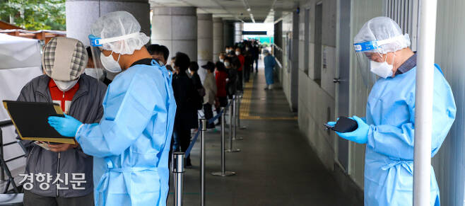 서울 종로구민회관에 설치된 코로나19 임시선별진료소에 지난 12일 시민들이 검사를 받기 위해 줄을 서 있다. 이석우 기자