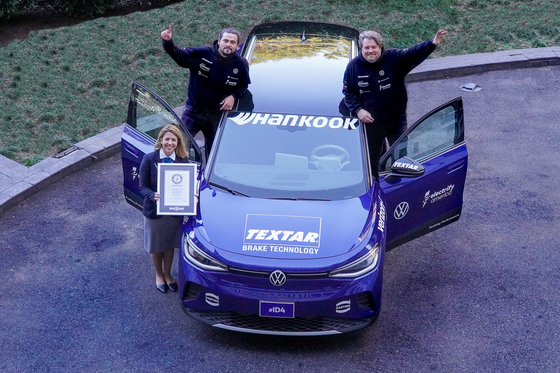 Long-distance driver Rainer Zietlow, right, and photographer Derek Collins, back left, pose with a Guinness World Records official and their Volkswagen ID.4 electric vehicle (EV) after setting a new world record for the longest journey by an EV in a single country on Hankook Tire & Technology’s EV-specific “Kinergy AS ev” tires. The duo traveled 35,000 miles across all 48 contiguous U.S. states in all-electric mode. [HANKOOK TIRE & TECHNOLOGY]