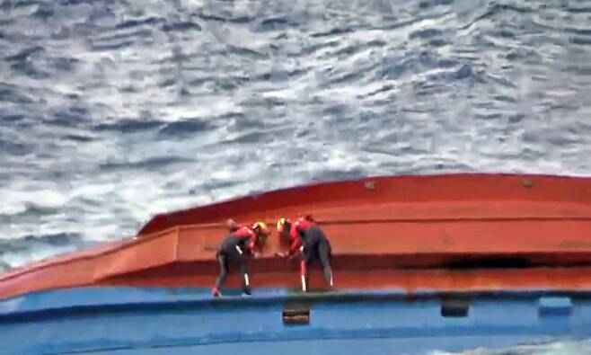지난 21일 오전 독도 북동쪽 약 168㎞ 공해에서 전복된 민간 어선에서 해경이 구조자 수색에 나서고 있다. /연합뉴스