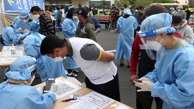지난 5월4일 강원 강릉시 보건소 앞에서 외국인 노동자들이 코로나19 검사에 필요한 안내를 받고 있다. 연합뉴스