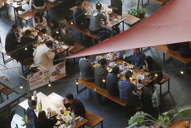 새로운 사회적 거리두기 조정안이 실시된 18일 낮 서울 종로구 광화문의 한 식당을 찾은 시민들이 식사를 하고 있다. 4인 이상이 모인 테이블이 곳곳에 보인다. 신소영 기자 viator@hani.co.kr