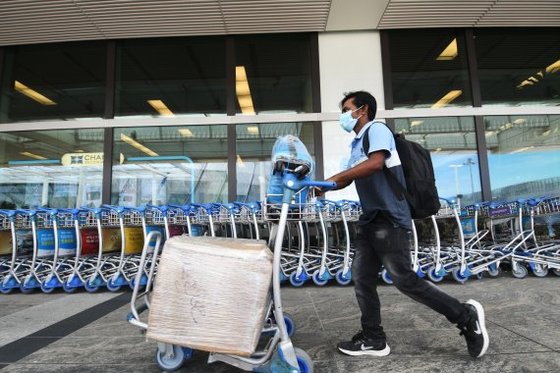 지난 8월19일 싱가포르 창이 공항 출국장에서 한 여행객이 짐을 끌고 나오고 있다. [신화=뉴시스]