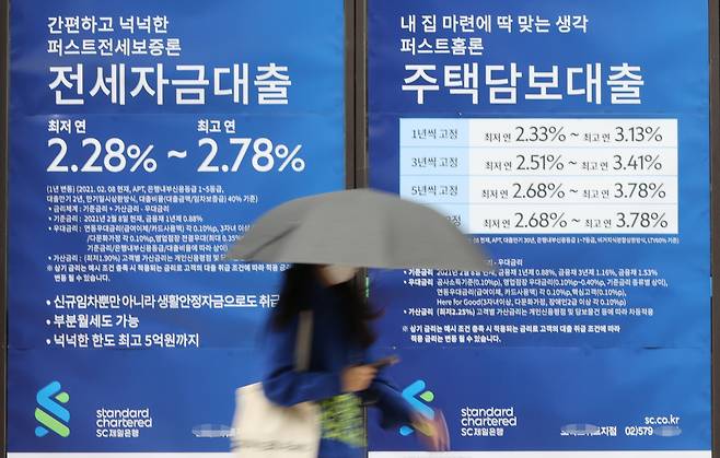 A woman walks past a commercial bank promoting “jeonse” loans in Seoul on Thursday. (Yonhap)