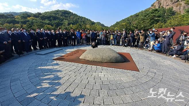 더불어민주당 이재명 대선후보가 22일 김해 봉하마을 노무현 대통령 묘역에 참배한 후 너럭바위를 어루만지고 있다. 송봉준 기자