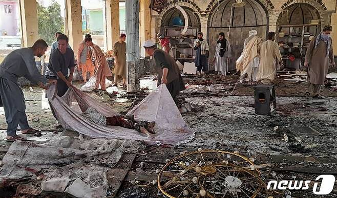 아프가니스탄 북동부 쿤드즈주 한 시아파 모스크에서 2021년 10월 8일(현지시간) 자폭 테러가 일어난 가운데, 현장에서 시신이 수습되는 모습. © AFP=뉴스1