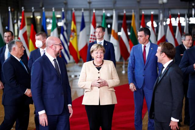 앙겔라 메르켈(가운데) 독일 총리가 21일 벨기에 브뤼셀에서 열린 유럽연합 정상회의에 참석해 에마뉘엘 마크롱(오른쪽) 프랑스 대통령, 샤를 미셸(왼쪽) EU정상회의 상임의장 등과 기념사진 촬영에 앞서 인사를 나누고 있다. 브뤼셀=로이터 연합뉴스