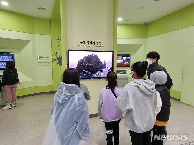 [서울=뉴시스] '2021 아름다운 우리 땅 독도탐방' 참가자들이 독도박물관에 설치된 독도 실시간 영상을 보고 있는 모습.