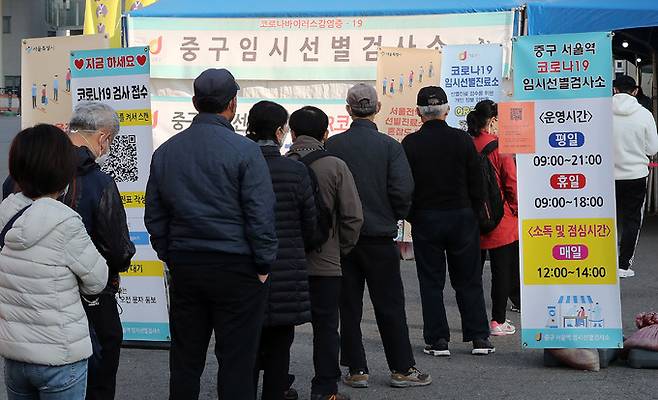 24일 서울역 광장에 마련된 신종 코로나바이러스 감염증(코로나19) 중구 임시 선별검사소를 찾은 시민들이 줄을 서 진단검사를 기다리고 있다. 뉴스1