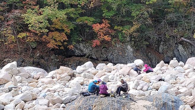 단풍구경에 지친 탐방객들이 계곡에 앉아 가을볕을 쬐며 쉬고 있다. 김상선 기자