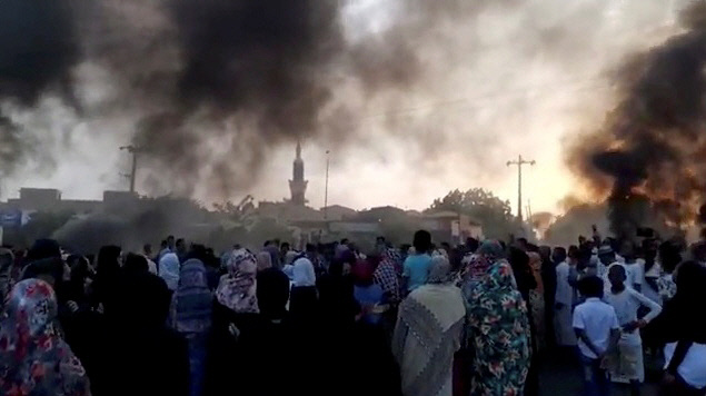 수단에서 25일(현지시간) 군사 쿠데타가 일어났다는 보도가 나온 가운데 거리로 모인 시민들이 연기에 휩싸여 있다. 카르툼 | 로이터연합뉴스