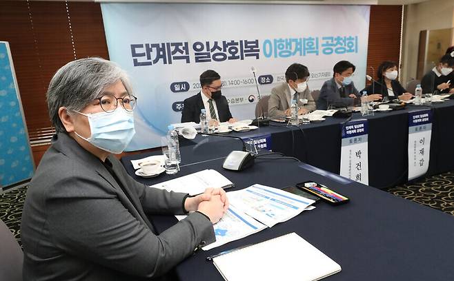 Korea Disease Control and Prevention Agency Commissioner Jeong Eun-kyeong (left) listens to a presentation at a public hearing on the plan to conduct a phased return to normal life held in Seoul on Monday. (Kang Chang-kwang/The Hankyoreh)