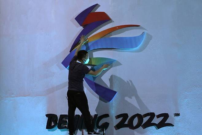 한 남성이 9월 17일(현지시각) 베이징에 있는 2022 베이징겨울올림픽 엠블럼을 정돈하고 있다. 베이징/로이터 연합뉴스