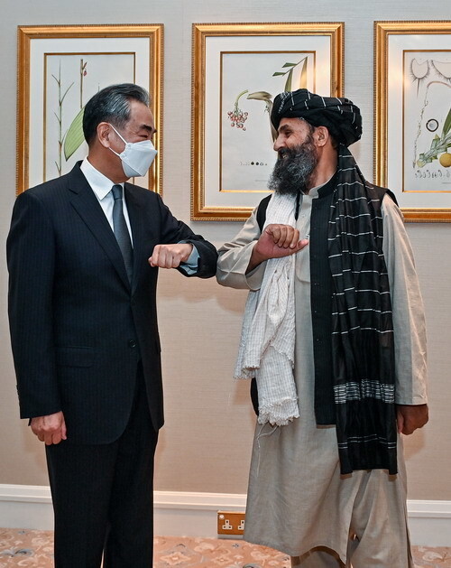 왕이 중국 외교부장이 25일 카타르 도하에서 아프가니스탄을 통치하고 있는 탈레반 과도정부의 압둘 가니 바라다르 부총리와 만나 인사하고 있다. 중국 외교부 제공