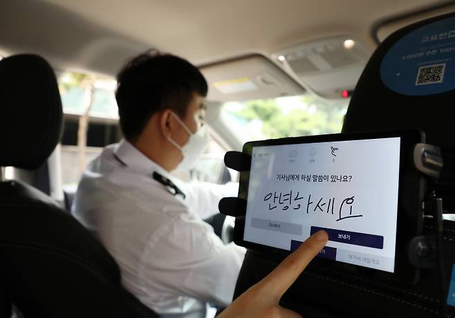 청각장애인 박광은씨가 운행하는 ‘고요한 M’ 택시에서 승객이 손글씨를 입력하고 있다.  작가 제공·경향신문 자료사진