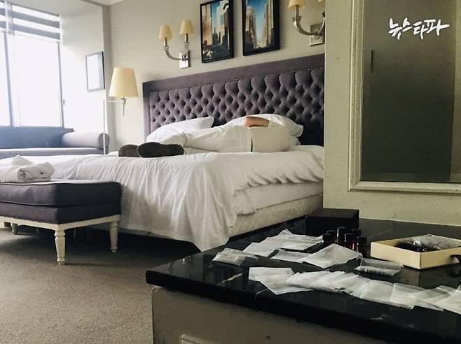 제보자가 찍은 최병민의 호텔 방 사진. 침대에 최병민이 누워 있고, 책상에는 약봉지가 널브러져 있다.