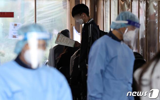 28일 오전 서울 송파구보건소 선별진료소에서 한 학생이 신종 코로나바이러스 감염증(코로나19) 검사를 기다리며 참고서를 읽고 있다. 2021.10.28/뉴스1 © News1 조태형 기자