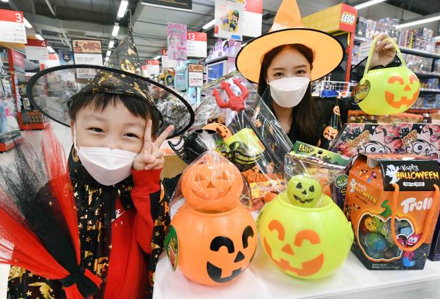 홈플러스 모델들이 25일 서울 강서구 홈플러스 강서점에서 ‘해피 핼러윈 대축제’ 행사 상품을 소개하고 있다. 홈플러스는 사탕과 초콜릿, 파티용 기획 상품을 비롯해 핼러윈 분위기를 연출할 수 있는 의상과 소품 등 560여 종을 내놓고, 행사 상품 2만 원 이상 구매 시 5,000원 상품권을 증정하는 이벤트를 오는 31일까지 진행한다./사진 제공=홈플러스