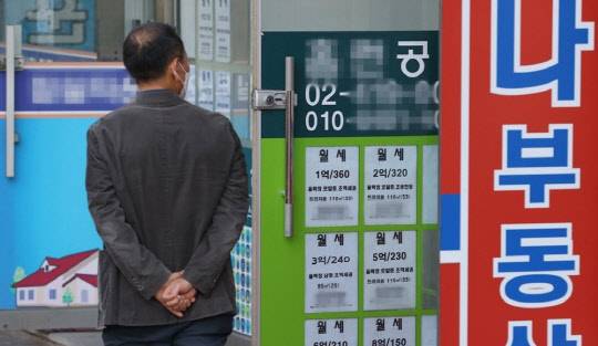 한 시민이 매물정보가 붙어 있는 부동산공인중개업소를 살펴보고 있다. <연합뉴스>