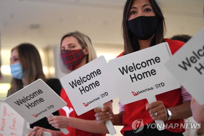 '환영합니다' (시드니 AFP=연합뉴스) 항공사 직원들이 호주 가족들의 귀국을 환영하는 팻말을 들고 있다. 2021. 11. 1 phtot@yna.co.kr