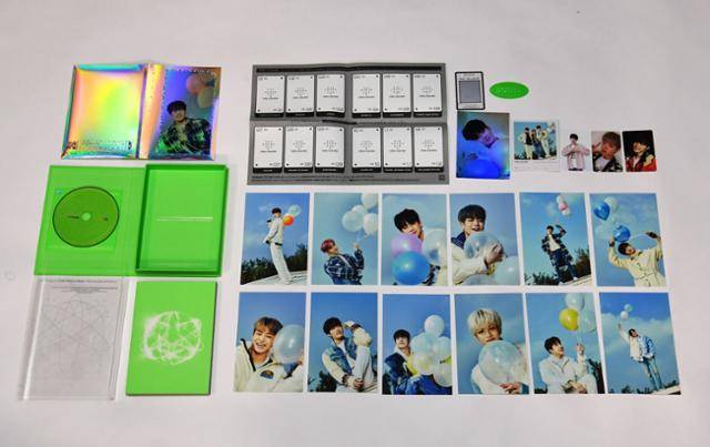 K팝그룹 '트레저'의 1집 음반 '트레저 이펙트(treasure effect)'의 구성품을 늘어놓아 봤다. 사진 왼쪽 위부터 시계 방향으로 포토카드 파일 홀더, 증강현실(AR) 카드보드, 각종 포토카드와 스티커, 사진 뒷면에 가사를 써둔 가사 엽서 12개, 사진집, 플라스틱 포장 필름, 종이박스와 CD이다. 배우한 기자