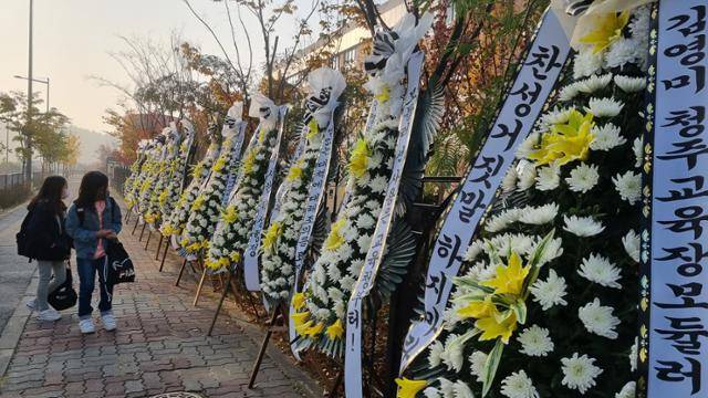 4일 청주 내곡초등학교 앞 길가에 놓인 근조화환을 지나가는 학생들이 바라보고 있다. 독자 제공