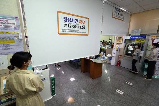 지난 7월 광주 5개 구청 민원실과 동 행정복지센터에서 점심시간 민원업무 휴무제가 시행에 들어간 1일 광산구 수완동 행정복지센터에서 공무원이 낮 12시가 되자 민원창구 가림막을 내리고 있다. 연합뉴스