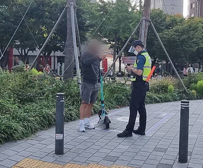 지난 10월 초순 서울 마포구에서 경찰이 헬멧을 미착용한 전동킥보드 이용자를 적발하고 있다. 김지헌 기자