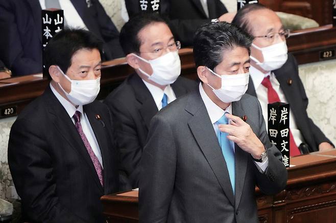 10월4일 아베 전 총리(왼쪽 세번째)가 일본 중의원에서 새 총리로 선출된 기시다 총 리(왼쪽 두번째) 옆을 지나 치듯 걸어가고 있다.ⓒAP 연합