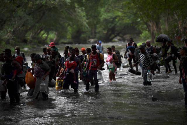 지난 9월 콜롬비아 아칸디 인근에서 미국을 향해 북상하는 아이티 이민자들이 파나마로 연결되는 다리엔 정글을 건너고 있다. '아메리칸드림'을 꿈꾸며 각종 위험이 도사린 정글도 마다하지 않고 미국으로 향하는 아이티 이민자들의 행렬은 끊이지 않고 있다. 연합뉴스