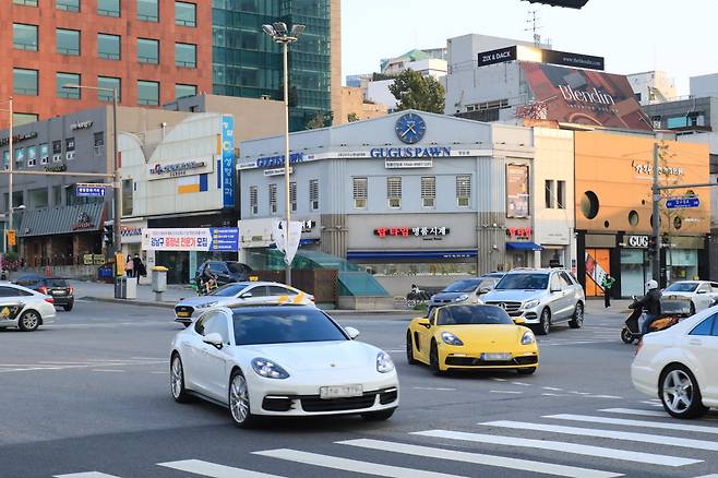 High-end cars are seen driving by luxury stores on Apgujeong Rodeo Street, Gangnam-gu, Seoul. (Son Ji-hyoung/The Korea Herald)