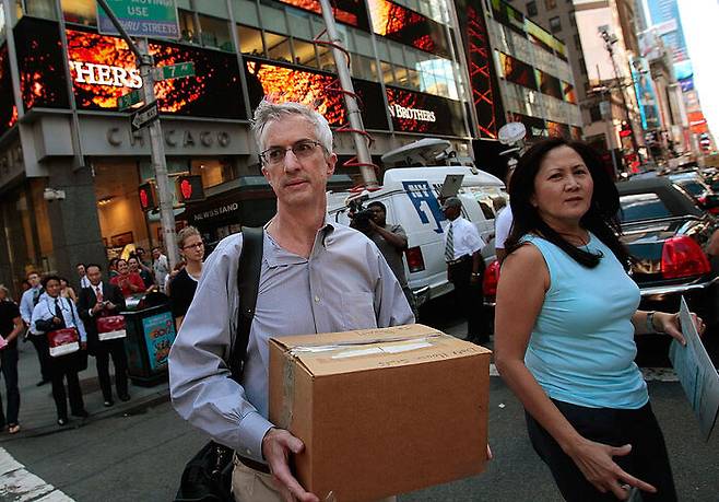 리먼 브러더스가 파산하자 직원이 짐을 싸서 본사를 빠져나오는 모습. 2008년 9월 뉴욕. 게티이미지 코리아.