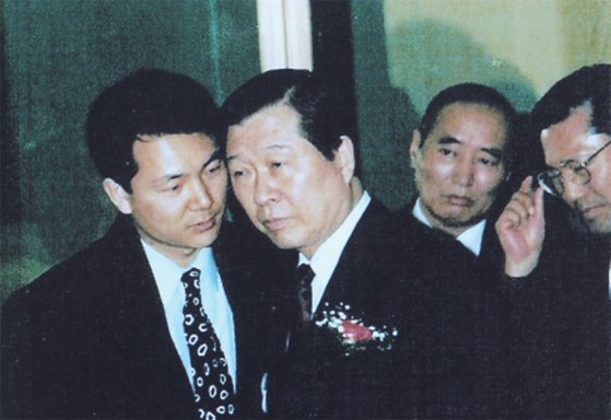 1992년 2월 8일 서울 여의도 63빌딩에서 열린 한 행사에 참석한 김대중 민주당 총재가 장성민 비서로부터 귀엣말 보고를 받고 있다.