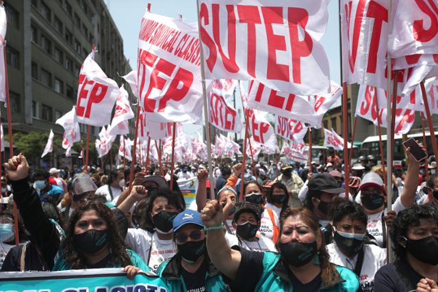 23일 페루 수도 리마에서 마스크를 쓴 공립학교 교사들이 전직 교사였던 페드로 카스티요 대통령에게 근로 조건 개선 등을 요구하는 시위를 하고 있다. AP 뉴시스