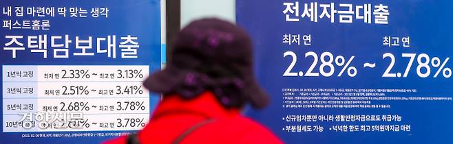 한국은행이 기준금리를 1.0%로 0.25%포인트 인상한 다음날인 26일 한 시민이 서울 강서구의 시중은행 외벽에 붙어 있는 주택담보대출과 전세자금대출 관련 안내문을 보고 있다. 이석우 기자