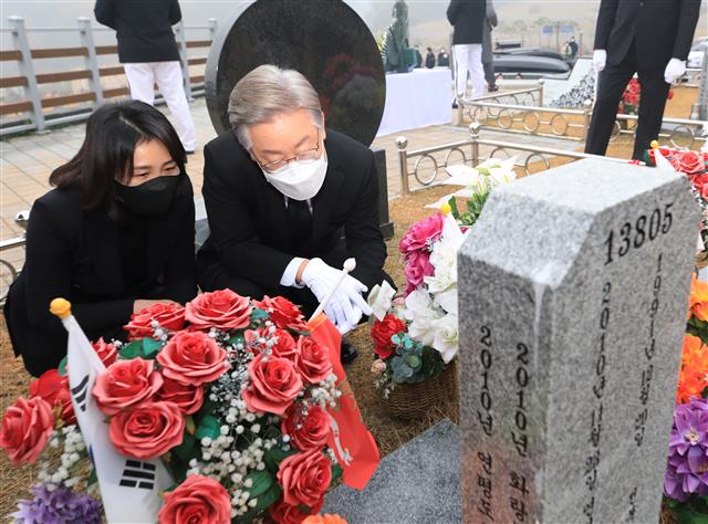 이재명(오른쪽) 더불어민주당 대선후보와 부인 김혜경씨가 21일 국립대전현충원 연평도 포격 전사자 묘역을 함께 참배한 뒤 비석을 살피고 있다.대전 뉴스1