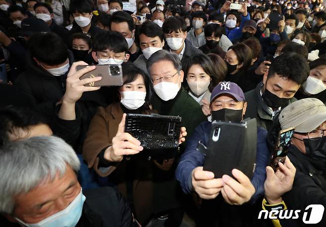 이재명 더불어민주당 대선후보와 배우자 김혜경 씨가 27일 전남 순천시 연향동 패션의 거리에서 시민들과 셀카를 찍고 있다./사진=뉴스1