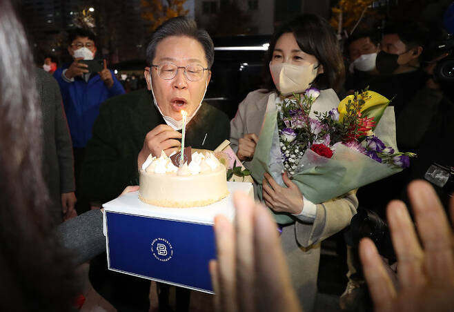 이재명 더불어민주당 대선후보와 배우자 김혜경 씨가 27일 전남 순천시 연향동 패션의 거리에서 시민들로부터 받은 생일 케이크의 촛불을 끄고 있다. 이 후보의 생일은 음력 1963년 10월23일이다. 뉴스1