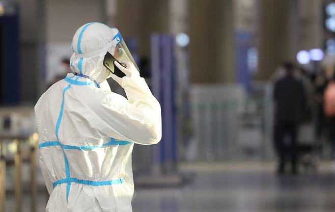 1일 인천공항에서 방역복을 입은 관계자가 통화하고 있다. / 사진 = 연합뉴스