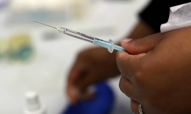 지난 11월30일(현지시간) 남아프리카공화국 케이프타운의 케이프타운 국제컨벤션센터에 마련된 희망 백신 접종소에서 한 의료인이 의료진 대상 부스터샷 접종 준비를 하고 있다. 케이프타운=AP뉴시스