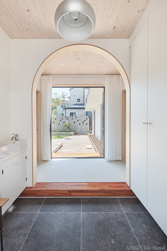 현관 정면에 보이는 게 집의 마당이다. 마당을 중심으로 두 개의 매스가 직교하며 분리돼 있다. 왼쪽이 자식 세대, 오른쪽이 부모님 세대의 공간이다. 이한울 건축사진작가 제공