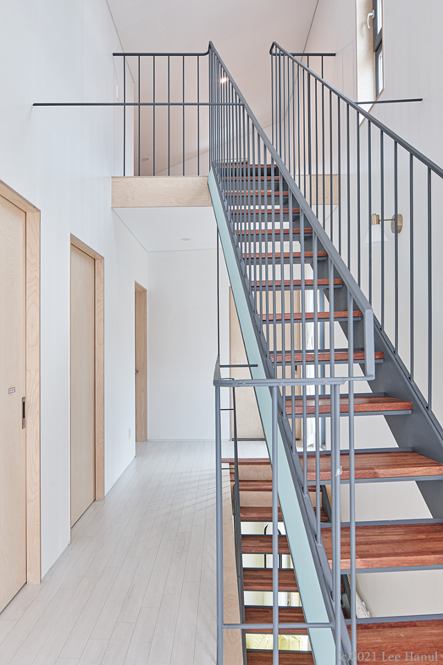 2층에서 다락으로 올라가는 계단. 살짝 비틀어진 계단 사이로 보이는 틈은 색다른 공간감을 만든다. 왼쪽은 세 자녀의 방이다. 이한울 건축사진작가 제공