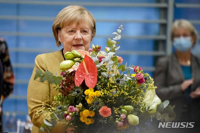 [베를린=AP/뉴시스] 앙겔라 메르켈 독일 총리가 24일(현지시간) 베를린 총리실에서 열리는 각료회의에 앞서 올라프 숄츠 부총리 겸 재무장관으로부터 꽃다발을 받아 들고 있다. 메르켈 총리는 지난 9월 선거 이후 새 내각을 구성하기 위한 마무리 협상이 진행 중인 가운데 이번 각료회의가 총리로서 마지막으로 여겨져 이 꽃다발을 받았다. 2021.11.24.
