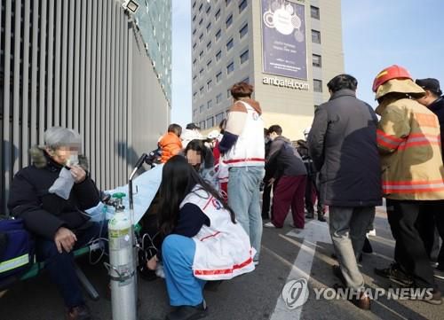 지난해 1월 서울 중구 그랜드 앰배서더 호텔 투숙객들이 화재가 발생하자 호텔 인근으로 대피해 산소 치료를 받고 있다. /연합뉴스