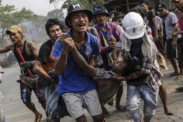지난 3월 미얀마 수도 양곤에서 군부의 유혈 진압에 부상을 당한 시민을 반(反) 군부 시위대가 다급히 옮기고 있다. /EPA연합뉴스