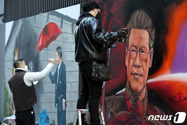 5일 서울 종로구의 한 중고서점 외벽에 더불어민주당, 국민의힘 대선 후보로 보이는 인물들의 새 벽화가 그려지고 있다. 2021.12.5/뉴스1 © News1 이승배 기자